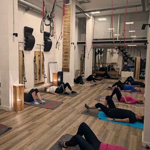 Clase en Studio Salux con las alumnas tumbadas boca arriba y las rodillas flexionadas