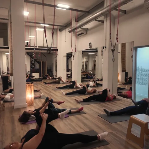 Clase de Pilates en Studio Salux con las alumnas tumbadas en colchoneta junto a la pared de muelles